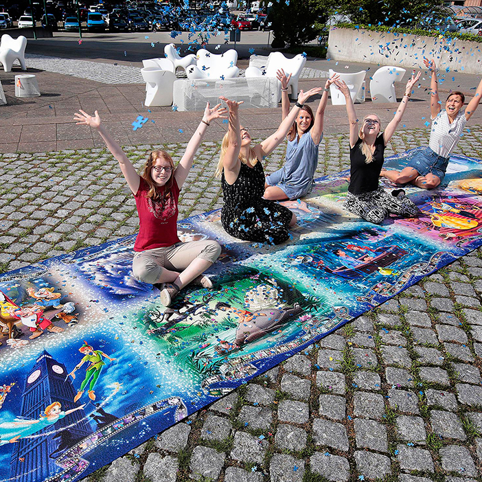 Les employés de Ravensburger assis sur le plus grand puzzle du monde